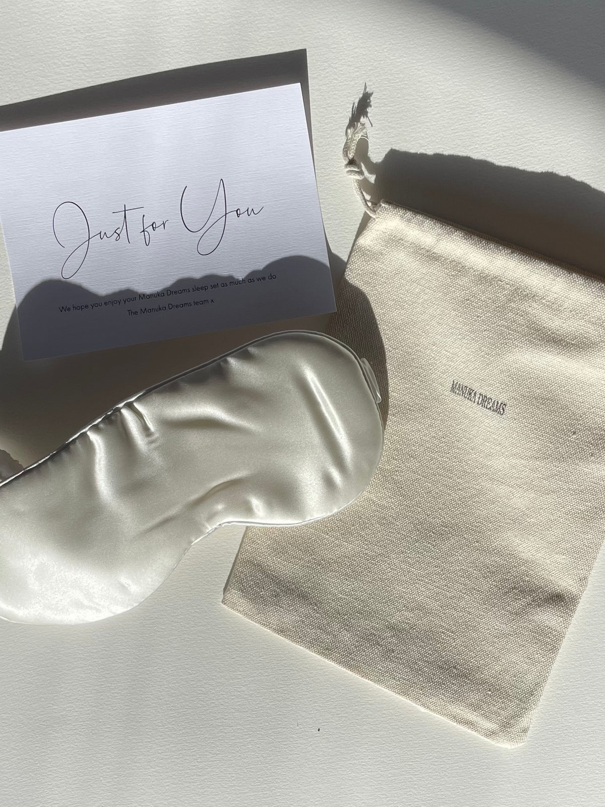 Silk eye mask with pouch and gift card on bright sunlit background